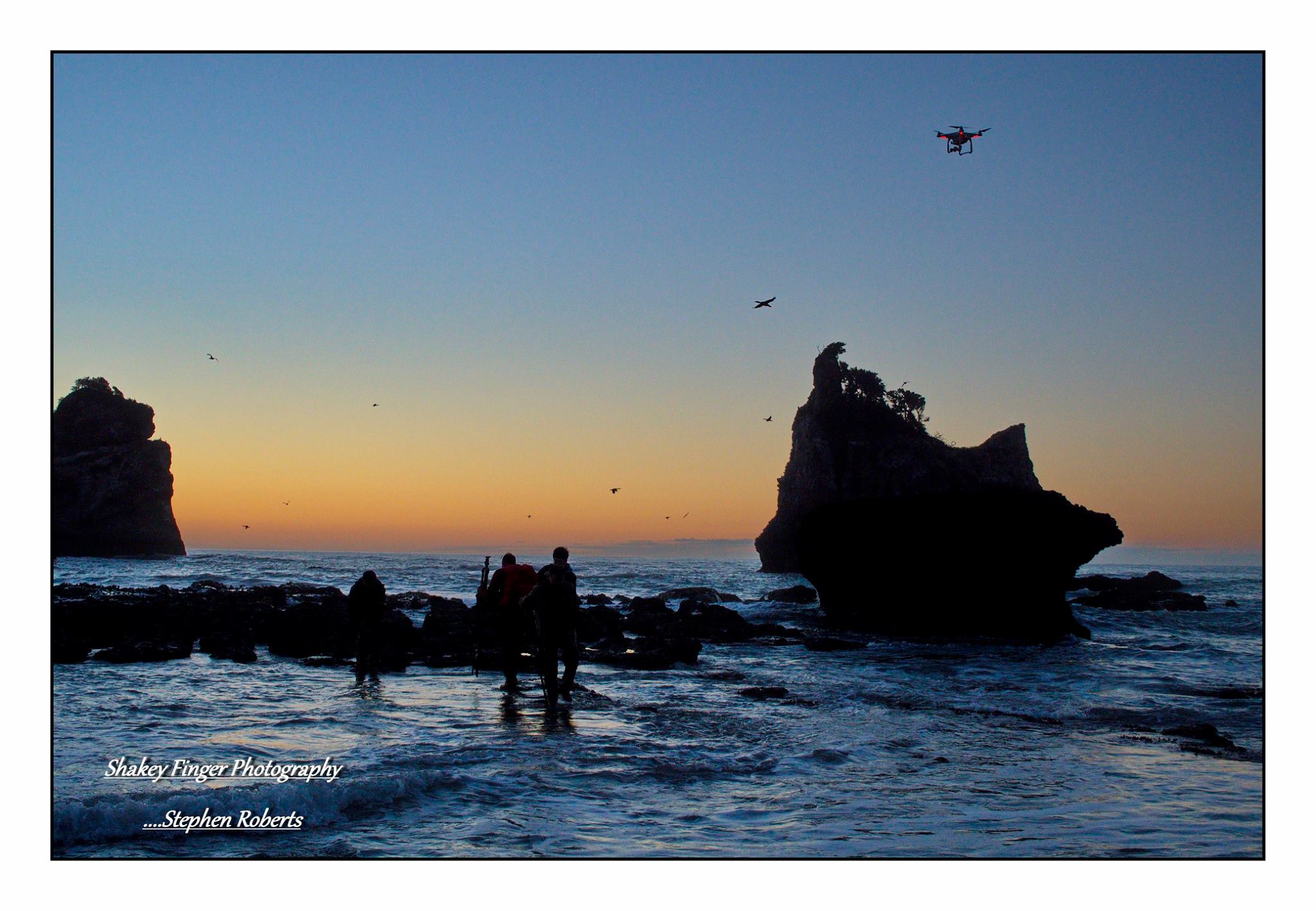 photographers out on the rocks at sunset motukiekie beach